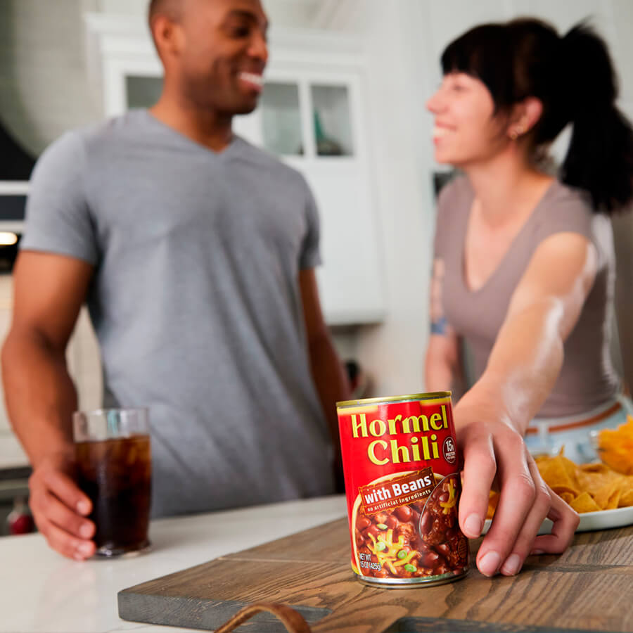 couple in kitchen with Hormel Chili can on cutting board