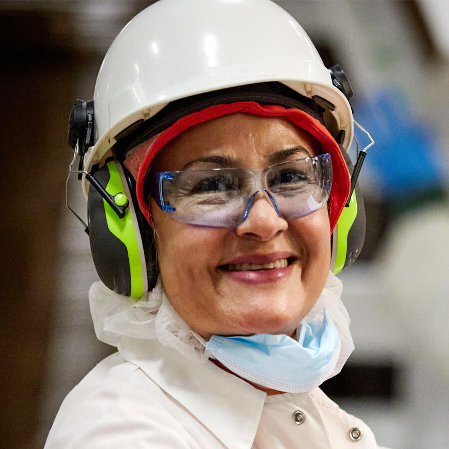 female team member in plant smiling